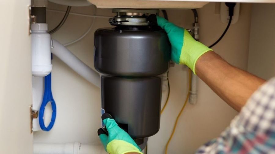 Plumber installaing garbage disposal.