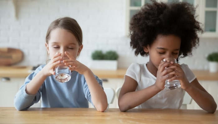 Two Children Drinking Water